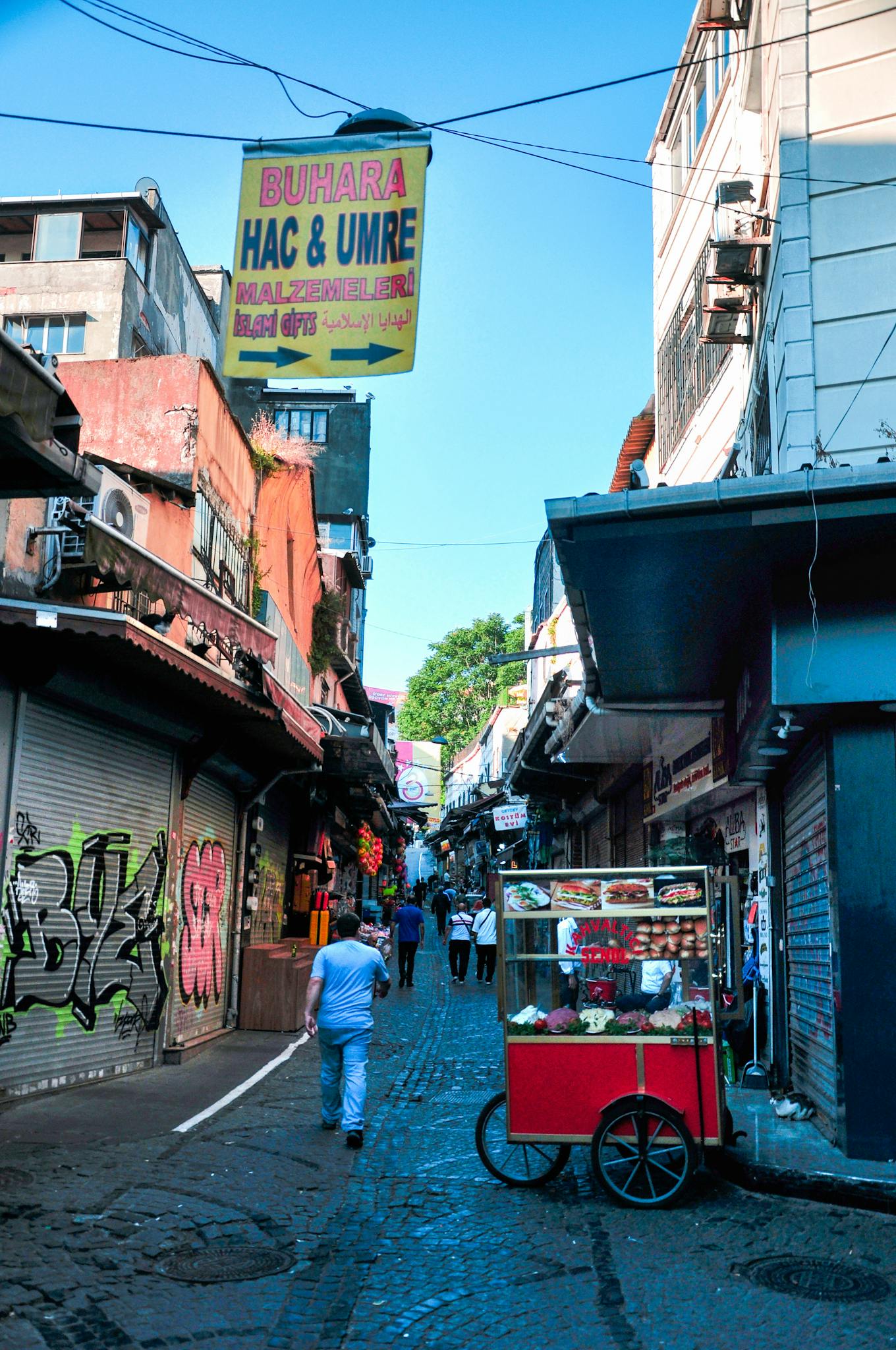 Colorful street in urban area with food cart and historic architecture, perfect for travel and lifestyle themes.