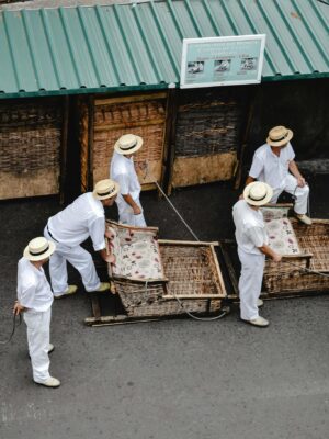 Monte sledge drivers in traditional attire preparing for the ride in Funchal, Madeira.