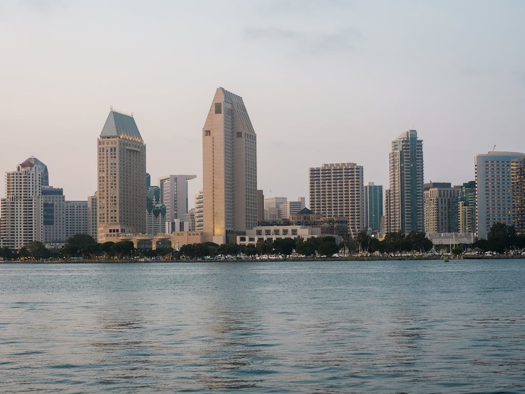 Cityscape of San Diego's skyline reflecting over the calm waters in the evening light.